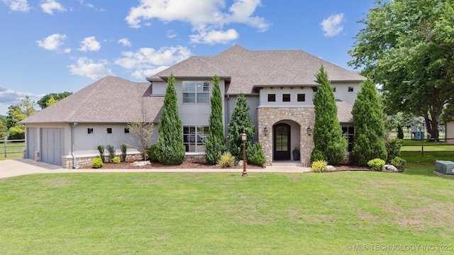 18319 E Red Fox Trl, Owasso, OK 74055 - french country style house featuring stucco siding, stone siding, concrete driveway, and an attached garage