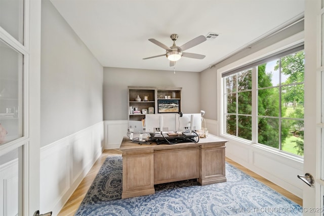 18319 E Red Fox Trl, Owasso, OK 74055 - home office with a ceiling fan, a wainscoted wall, a decorative wall, and light wood-style flooring