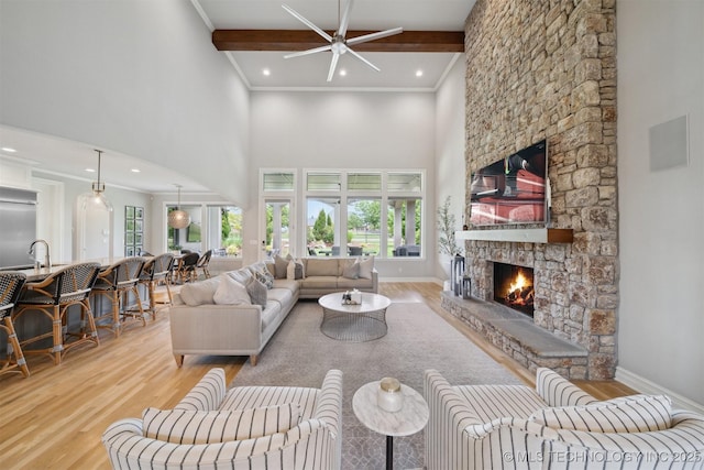 18319 E Red Fox Trl, Owasso, OK 74055 - living area with a fireplace, wood finished floors, a towering ceiling, healthy amount of natural light, and crown molding
