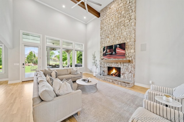 18319 E Red Fox Trl, Owasso, OK 74055 - living room featuring ceiling fan, a fireplace, a high ceiling, wood finished floors, and beamed ceiling