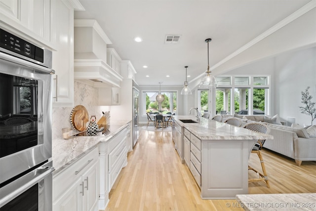 18319 E Red Fox Trl, Owasso, OK 74055 - kitchen with a sink, double oven, a kitchen breakfast bar, open floor plan, and decorative backsplash