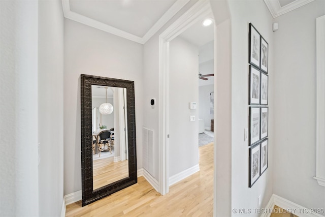 18319 E Red Fox Trl, Owasso, OK 74055 - hallway featuring light wood-type flooring, ornamental molding, baseboards, and arched walkways