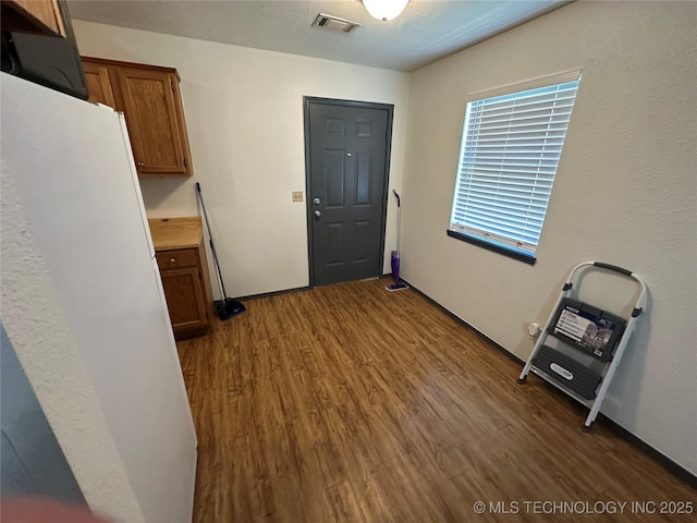 206 I St NE, Ardmore, OK 73401 - interior space featuring wood finished floors, brown cabinets, light countertops, and freestanding refrigerator