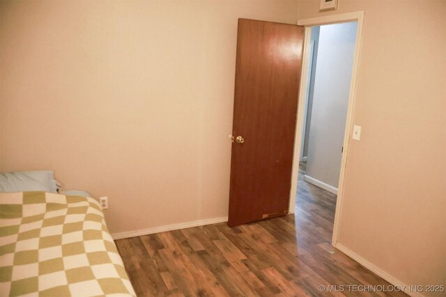 101 Honeysuckle Ln, Pryor, OK 74361 - unfurnished bedroom with wood finished floors and baseboards