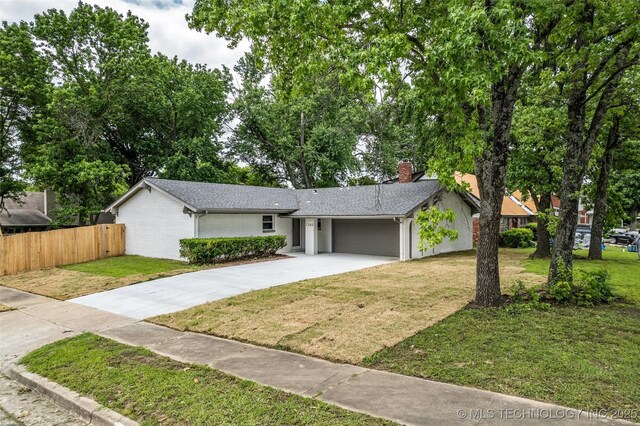 7362 S 68th E Ave, Tulsa, OK 74133 - view of front of house featuring concrete driveway, an attached garage, a chimney, brick siding, and a shingled roof