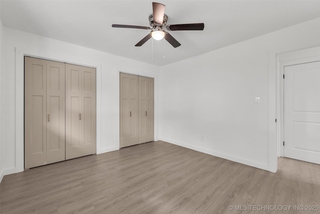 7362 S 68th E Ave, Tulsa, OK 74133 - unfurnished bedroom with multiple closets, light wood-style flooring, baseboards, and ceiling fan