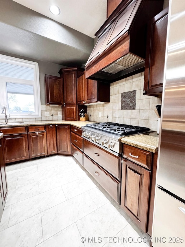 4418 N Little, Cushing, OK 74023 - kitchen featuring high quality fridge, a sink, stainless steel gas stovetop, decorative backsplash, and premium range hood