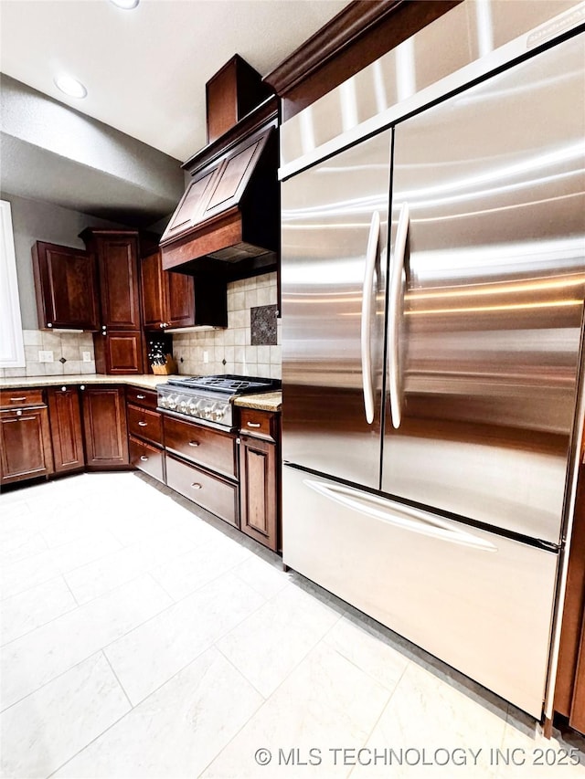 4418 N Little, Cushing, OK 74023 - kitchen with stainless steel appliances, decorative backsplash, light countertops, recessed lighting, and custom range hood
