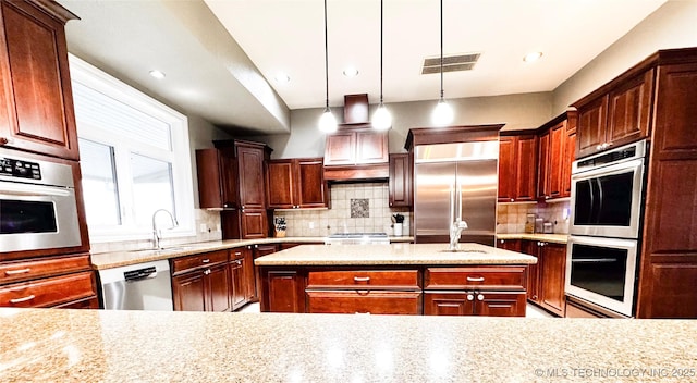 4418 N Little, Cushing, OK 74023 - kitchen featuring stainless steel appliances, a sink, decorative backsplash, a kitchen island, and decorative light fixtures