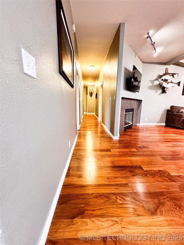 4418 N Little, Cushing, OK 74023 - hall with wood finished floors, baseboards, track lighting, a textured wall, and a textured ceiling
