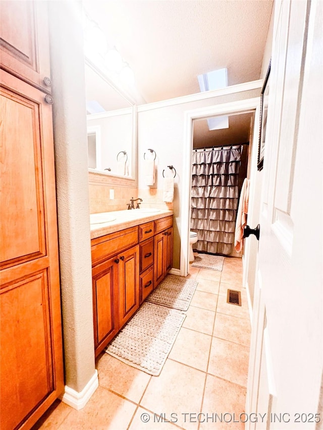 4418 N Little, Cushing, OK 74023 - bathroom featuring toilet, double vanity, tile patterned floors, and tasteful backsplash