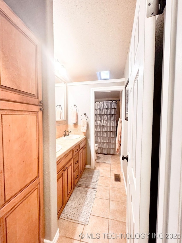 4418 N Little, Cushing, OK 74023 - bathroom with toilet, double vanity, tile patterned flooring, and a textured ceiling