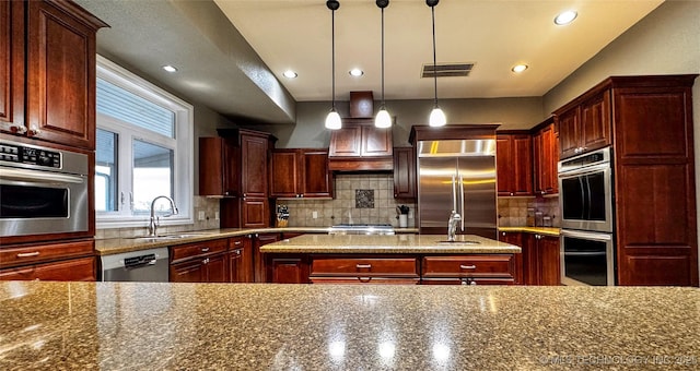 4418 N Little, Cushing, OK 74023 - kitchen with stainless steel appliances, a sink, decorative backsplash, a kitchen island, and recessed lighting
