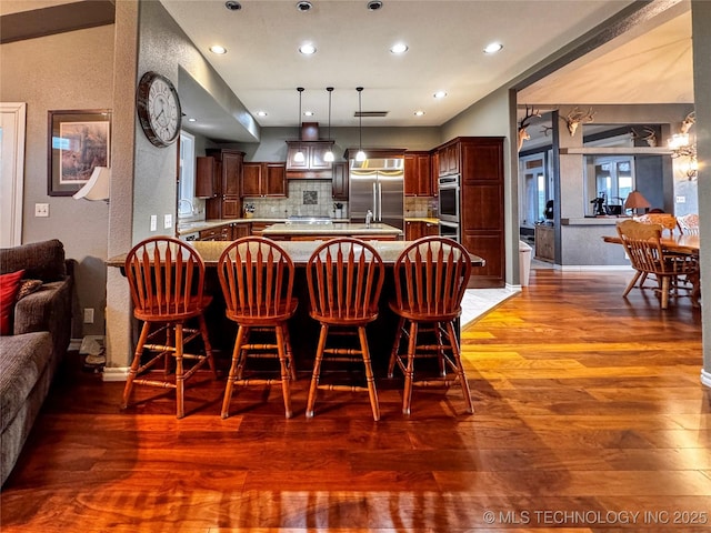 4418 N Little, Cushing, OK 74023 - kitchen with stainless steel appliances, open floor plan, light countertops, wood finished floors, and recessed lighting