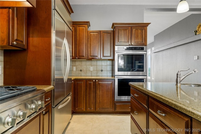 4418 N Little, Cushing, OK 74023 - kitchen with appliances with stainless steel finishes, backsplash, light stone countertops, and light tile patterned floors