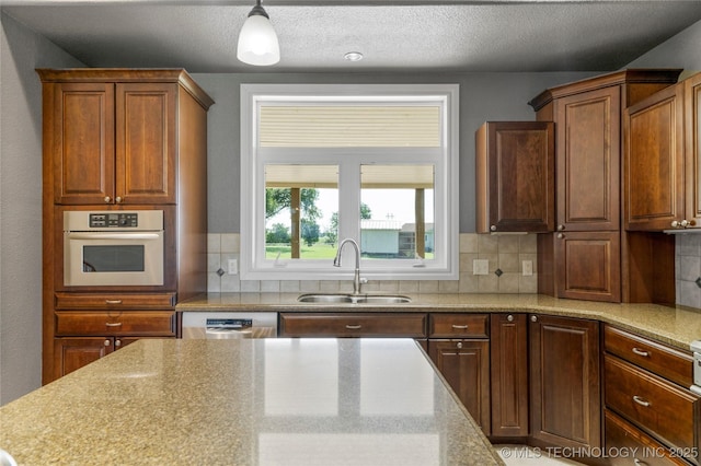 4418 N Little, Cushing, OK 74023 - kitchen with stainless steel appliances, decorative backsplash, decorative light fixtures, light stone countertops, and a textured ceiling