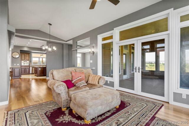 4418 N Little, Cushing, OK 74023 - living room featuring a chandelier, light wood-type flooring, lofted ceiling, ceiling fan, and french doors