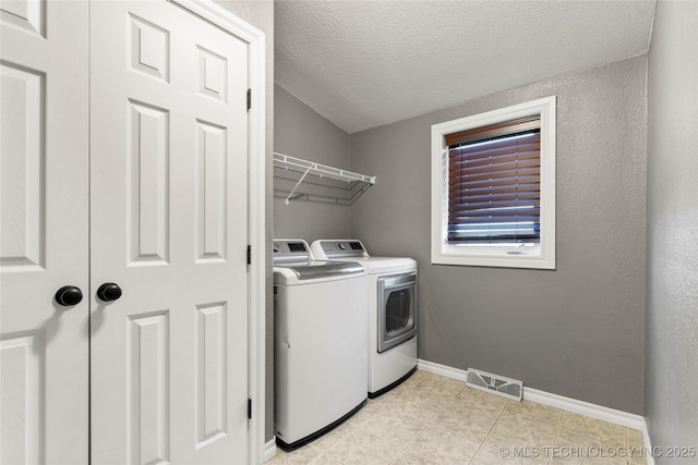 4418 N Little, Cushing, OK 74023 - laundry room with washer and clothes dryer, a textured ceiling, and light tile patterned floors