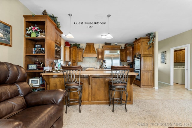 4418 N Little, Cushing, OK 74023 - kitchen featuring open floor plan, appliances with stainless steel finishes, washer / dryer, premium range hood, and a kitchen bar