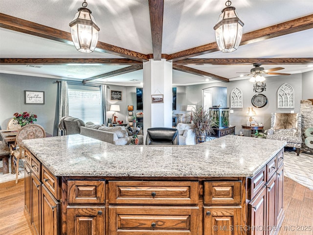 830294 S 3530, Stroud, OK 74079 - kitchen featuring open floor plan, ceiling fan, light wood-style flooring, brown cabinets, and a center island