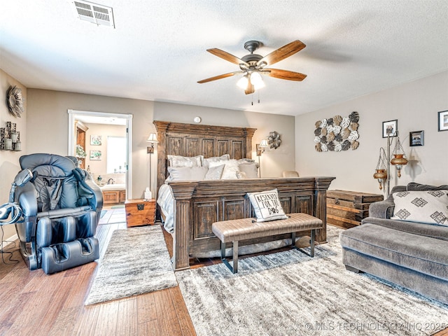 830294 S 3530, Stroud, OK 74079 - bedroom featuring wood finished floors, a textured ceiling, ensuite bath, and a ceiling fan
