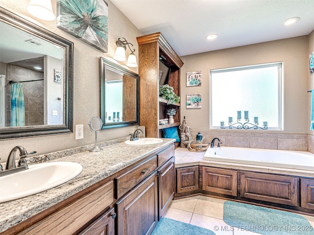 830294 S 3530, Stroud, OK 74079 - bathroom featuring a garden tub, double vanity, a tile shower, tile patterned flooring, and a textured wall