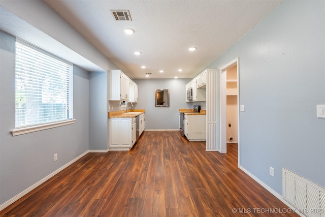 1605 W Montgomery St, Broken Arrow, OK 74012 - kitchen with stainless steel appliances, dark wood-style floors, white cabinets, baseboards, and recessed lighting