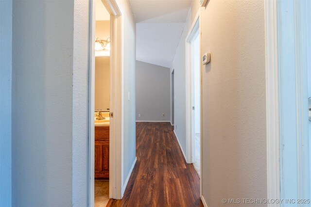 1605 W Montgomery St, Broken Arrow, OK 74012 - hallway featuring wood finished floors, vaulted ceiling, a sink, and baseboards