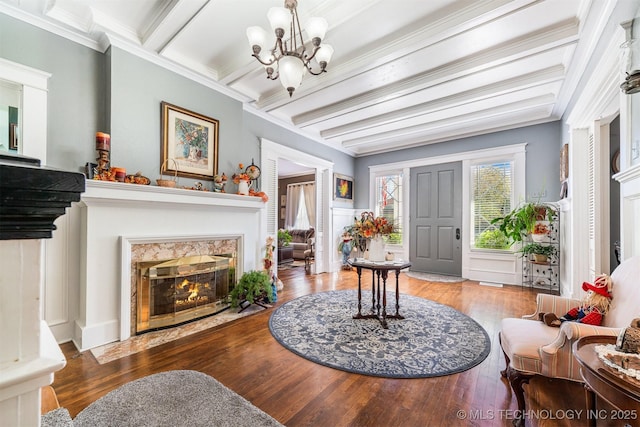 211 F SW, Ardmore, OK 73401 - foyer with beamed ceiling, a fireplace, wood finished floors, a chandelier, and crown molding