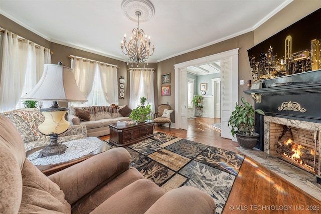 211 F SW, Ardmore, OK 73401 - living room featuring a chandelier, a fireplace, crown molding, wood finished floors, and baseboards