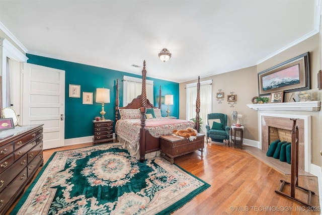 211 F SW, Ardmore, OK 73401 - bedroom with crown molding, wood finished floors, a premium fireplace, and baseboards