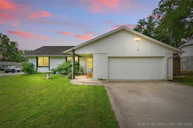 401 W Birmingham St, Broken Arrow, OK 74011 - view of front of property featuring brick siding, driveway, a lawn, board and batten siding, and an attached garage