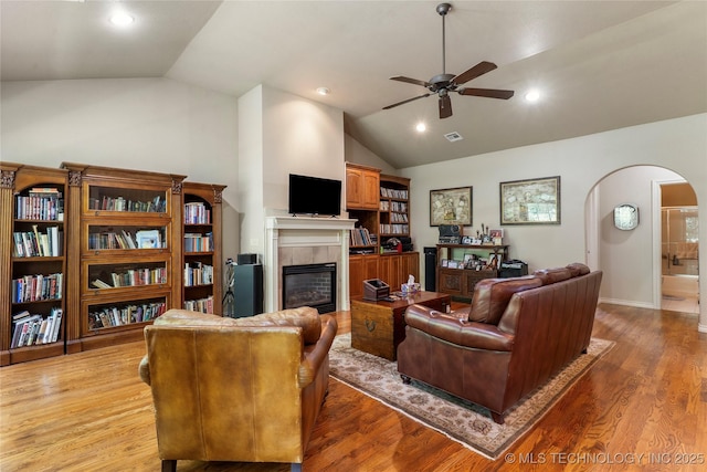 420 Fox Wood Dr, Sapulpa, OK 74066 - living room with lofted ceiling, arched walkways, ceiling fan, a tile fireplace, and light wood finished floors