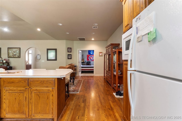 420 Fox Wood Dr, Sapulpa, OK 74066 - kitchen with white appliances, arched walkways, light countertops, dark wood-type flooring, and recessed lighting