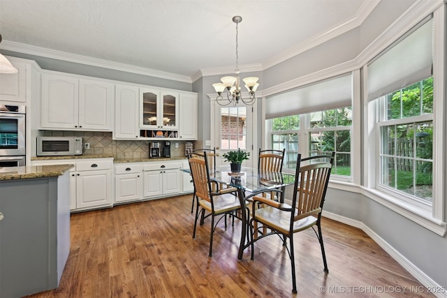 11586 S 66th E Ave, Bixby, OK 74008 - dining room featuring wood finished floors, a chandelier, crown molding, and baseboards