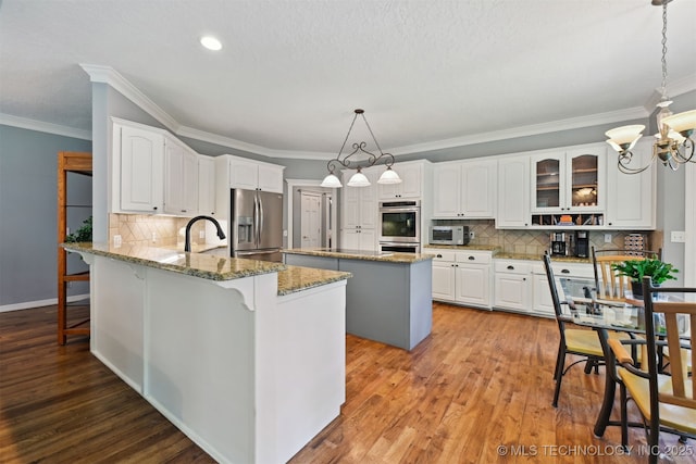 11586 S 66th E Ave, Bixby, OK 74008 - kitchen with stainless steel appliances, backsplash, a breakfast bar, a chandelier, and light stone counters