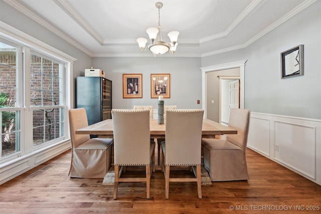 11586 S 66th E Ave, Bixby, OK 74008 - dining area with a chandelier, wood finished floors, a raised ceiling, ornamental molding, and a wainscoted wall