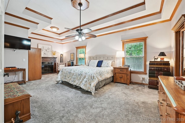 11586 S 66th E Ave, Bixby, OK 74008 - carpeted bedroom with ornamental molding, a raised ceiling, multiple windows, a glass covered fireplace, and baseboards