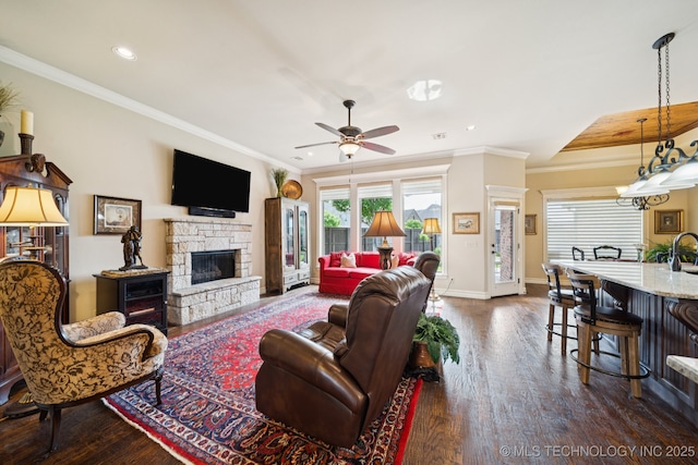 13234 S 68th E Ave, Bixby, OK 74008 - living room with dark wood-type flooring, crown molding, recessed lighting, a stone fireplace, and baseboards