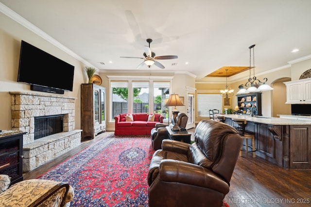 13234 S 68th E Ave, Bixby, OK 74008 - living room featuring a stone fireplace, dark wood-style floors, ceiling fan, a chandelier, and ornamental molding