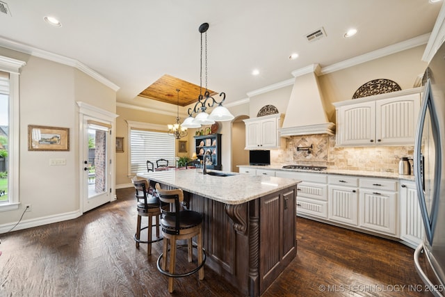 13234 S 68th E Ave, Bixby, OK 74008 - kitchen featuring a sink, custom exhaust hood, dark wood-style floors, backsplash, and ornamental molding