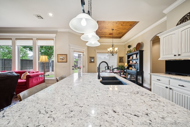 13234 S 68th E Ave, Bixby, OK 74008 - kitchen with a sink, light stone counters, white cabinets, hanging light fixtures, and a chandelier