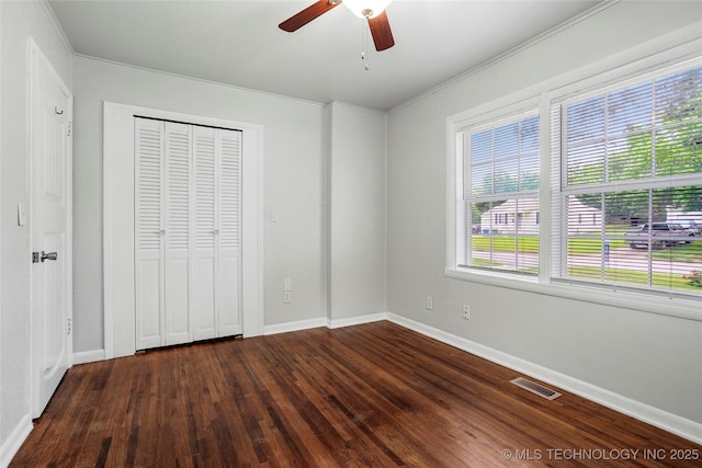 7128 E 5th Pl, Tulsa, OK 74112 - unfurnished bedroom featuring dark wood-type flooring, crown molding, baseboards, a closet, and ceiling fan