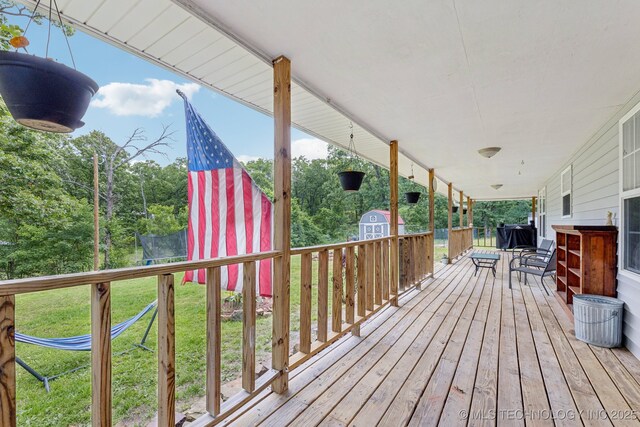 363270 E 5700th Rd, Jennings, OK 74038 - wooden terrace featuring a trampoline and a lawn