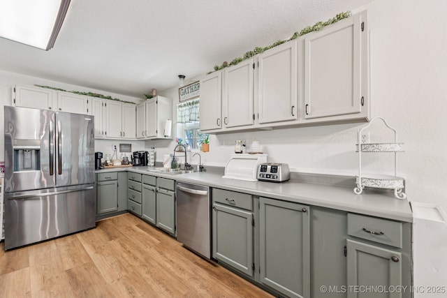 363270 E 5700th Rd, Jennings, OK 74038 - kitchen featuring stainless steel appliances, a sink, gray cabinetry, light wood finished floors, and light countertops