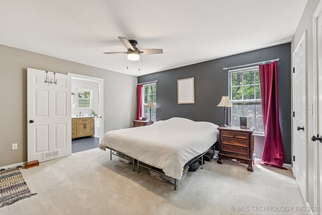 363270 E 5700th Rd, Jennings, OK 74038 - carpeted bedroom featuring ensuite bath, ceiling fan, a sink, and baseboards