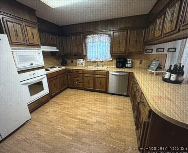 5616 Stonecreek, Durant, OK 74701 - kitchen with white appliances, light countertops, a sink, dark brown cabinets, and under cabinet range hood