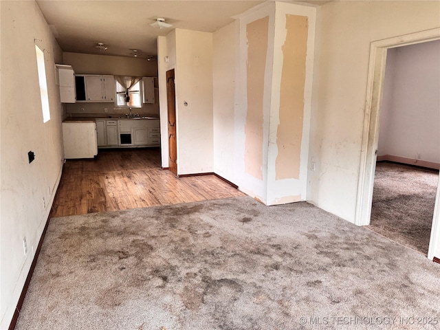 622 H NW, Ardmore, OK 73401 - unfurnished living room with carpet, a sink, and baseboards