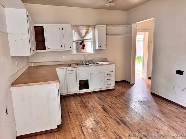 622 H NW, Ardmore, OK 73401 - kitchen featuring a sink, white cabinetry, hardwood / wood-style flooring, and baseboards