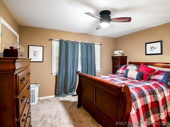 801 S Rennie St, Ada, OK 74820 - bedroom with multiple windows, light colored carpet, and a ceiling fan